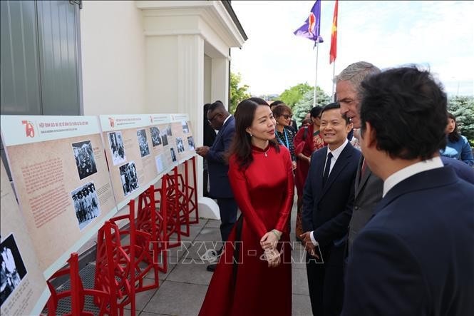 Deputy Minister of Foreign Affairs Nguyen Minh Hang (in red) and visitors at the exhibition. (Photo: VNA) Geneva photo exhibition sheds light on 1954 agreement -0