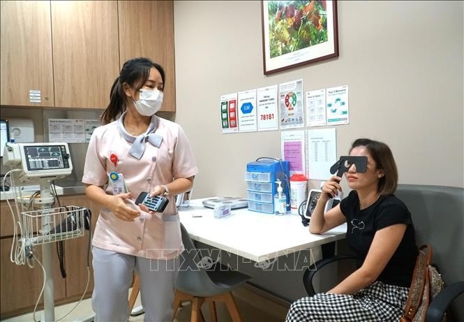 A person gets her eyes tested by a Sunway Medical Centre's staff. (Photo: VNA) Malaysia-Vietnam Friendship Association cares for OVs’ health -0