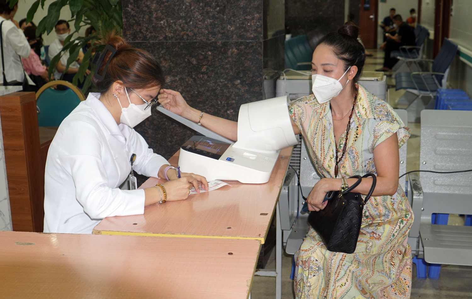Một nữ bệnh nhân đo huyết áp trước khi vào khám Ban giám đốc Bệnh viên Bạch Mai tham gia khám bệnh trong khung giờ 17h đến 21h -0