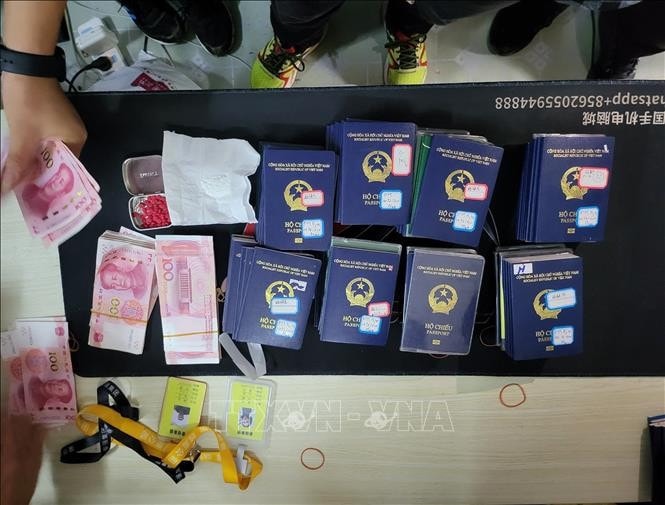Nearly 100 passports are confiscated (Photo: VNA) Cyber fraud ring bust in Golden Triangle Special Economic Zone -0