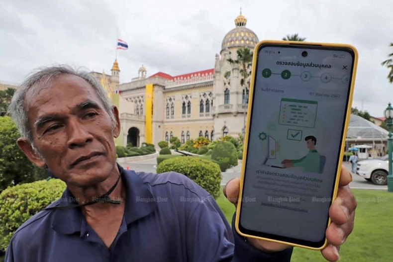 A Thai gardener shows a message on his phone in response to his registration for the digital wallet scheme. (bangkokpost.com) Thailand to kick off large-scale consumption stimulus programme -0