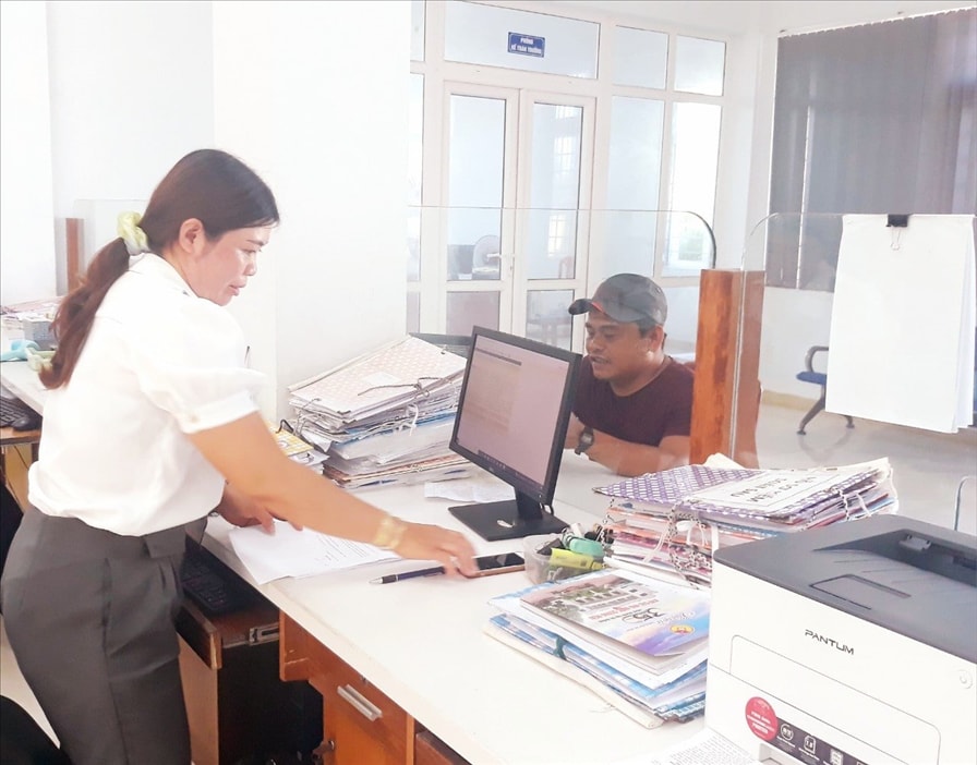 Công chức KBNN Lý Sơn đang làm thủ tục chi tiền hỗ trợ cho ngư dân. Ảnh: Phan Hiệp