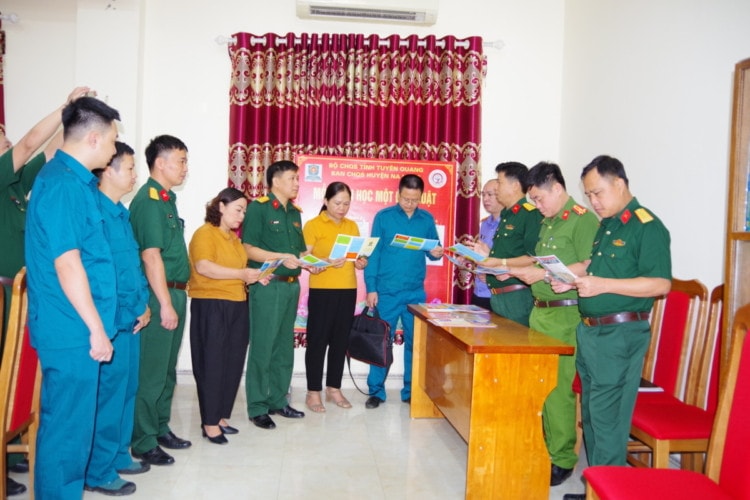 Đại tá Nguyễn Thành An, Phó Chính ủy Bộ CHQS tỉnh và các đại biểu trao đổi kinh nghiệm về công tác tuyên truyền, phổ biến giáo dục pháp luật tại cơ sở. Ảnh: Chí Công