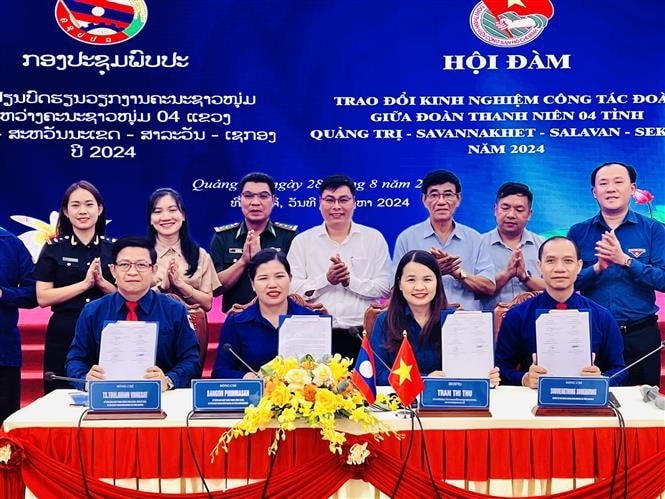 The youth unions of Quang Tri province and three Lao provinces - Savannakhet, Salavan and Sekong- sign a joint message of the friendship programme on August 28. (Photo: VNA) Vietnamese, Lao provinces exchange experience in youth activities -0