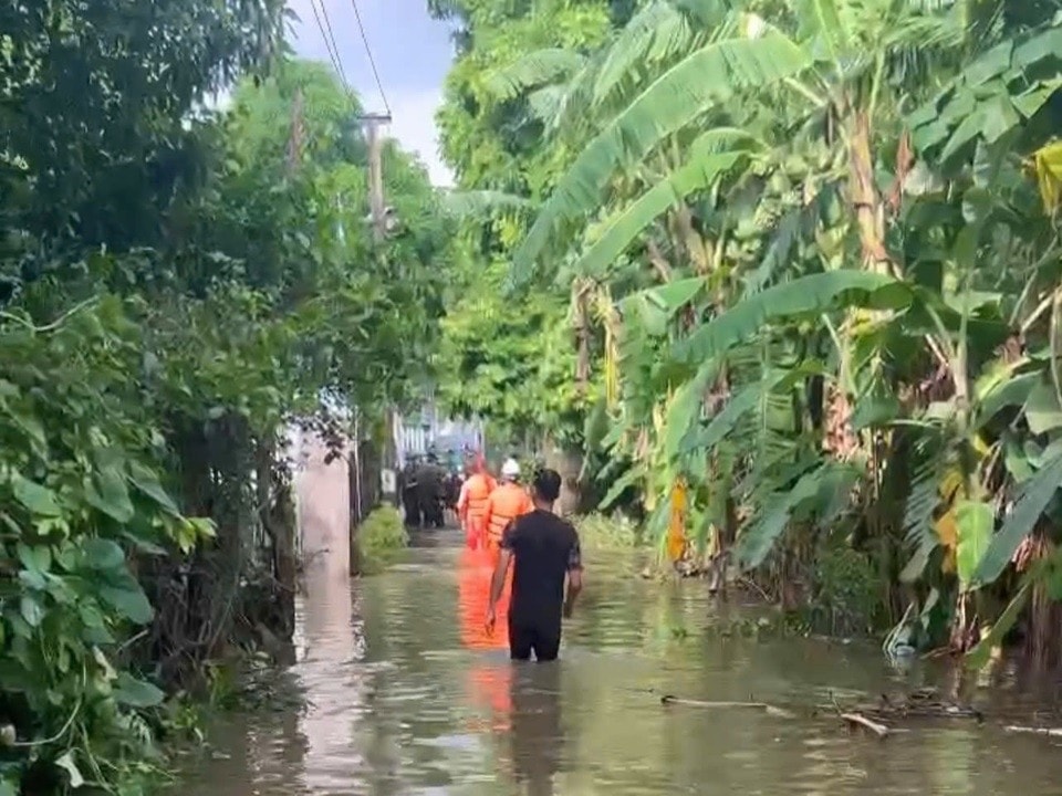 Cán bộ, công nhân viên Điện lực lội nước đến điểm xử lý sự cố. Ảnh NPC.jpg