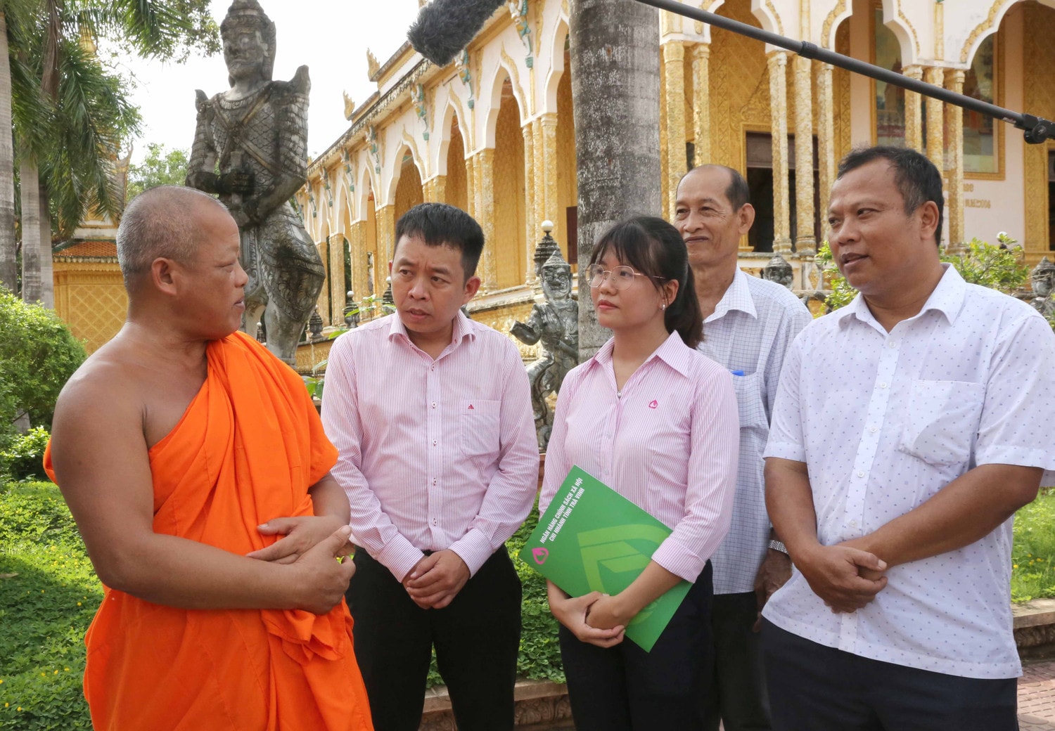 Cán bộ NHCSXH tỉnh Trà Vinh và Sư cả chùa Giồng Lớn Trương Văn Biển trao đổi phương án tuyên truyền các chính sách cho vay mới tới bà con. Ảnh: Đức Kiên