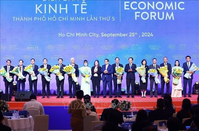 Thủ tướng Phạm Minh Chính tặng hoa chúc mừng các thành viên Trung tâm Cách mạng Công nghiệp lần thứ 4 (C4IR). Ảnh: Dương Giang/TTXVN
