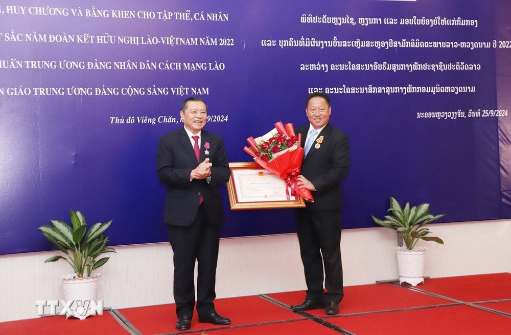 Thừa ủy quyền của Đảng và Nhà nước Việt Nam, ông Lại Xuân Môn, Ủy viên Trung ương Đảng, Phó Trưởng ban Thường trực Ban Tuyên giáo trao tặng Huân chương Độc lập hạng Nhì cho Ủy viên Trung ương Đảng, Phó Trưởng ban Thường trực Ban Tuyên huấn Lào Laopaoxiong Navongxay. Ảnh: Xuân Tú/TTXVN