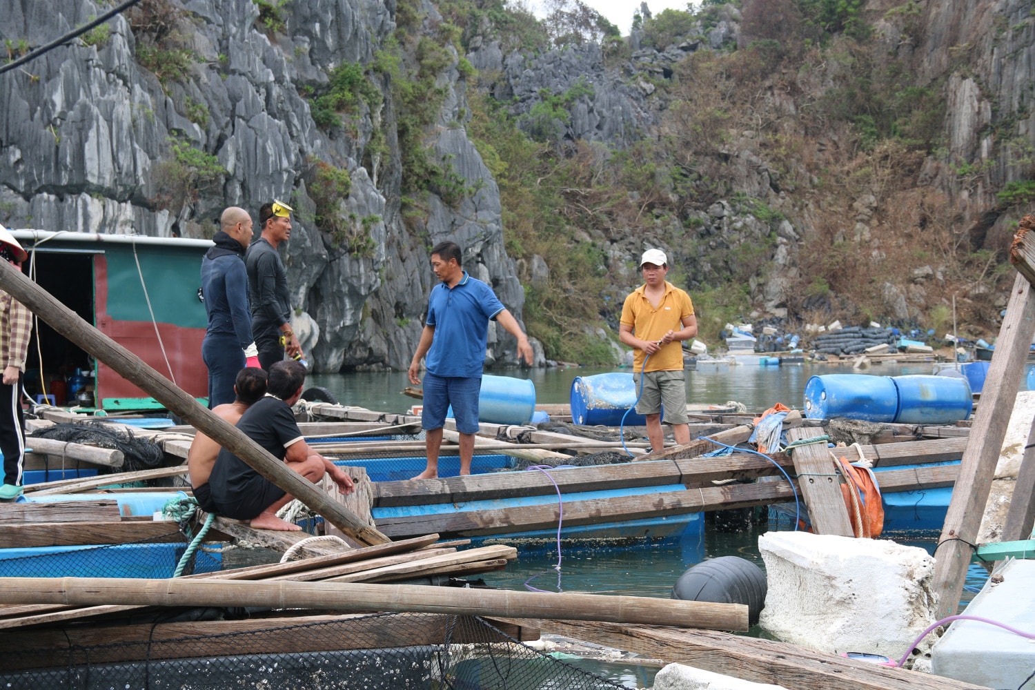 Người dân huyện Vân Đồn và các thợ lặn chuyên nghiệp nghiên cứu phương án trục vớt tàu bị đắm. Ảnh: P. Nam