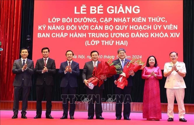 Đại diện lớp học tặng hoa GS.TS Nguyễn Xuân Thắng và PGS.TS Nguyễn Duy Bắc. Ảnh: Văn Điệp/TTXVN