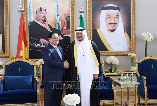 Quan chức Saudi Arabia đón Thủ tướng Phạm Minh Chính. Ảnh: Dương Giang/TTXVN
