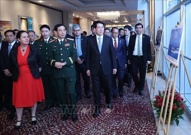 Chủ tịch nước Lương Cường và các đại biểu xem trưng bày ảnh về thành tựu của Quân đội nhân dân Việt Nam. Ảnh: Lâm Khánh/TTXVN