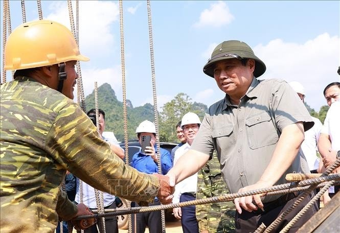 Thủ tướng Phạm Minh Chính động viên công nhân thi công dự án cao tốc Đồng Đăng - Trà Lĩnh. Ảnh: Dương Giang/TTXVN