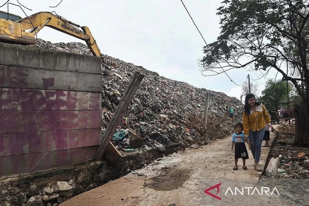 Two residents pass beside the boundary wall of the Burangkeng Final Disposal Site (TPA) which was damaged by a landslide in Bekasi Regency, West Java, November 12. (Photo: Antara/ Fakhri Hermansyah/rwa) Two residents pass beside the boundary wall of the Burangkeng Final Disposal Site (TPA) which was damaged by a landslide in Bekasi Regency, West Java, November 12. (Photo: Antara/ Fakhri Hermansyah/rwa)