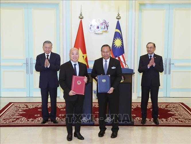 Tổng Bí thư Tô Lâm và Thủ tướng Malaysia Anwar Ibrahim chứng kiến trao đổi văn kiện hợp tác giữa hai nước Ảnh: Thống Nhất/TTXVN