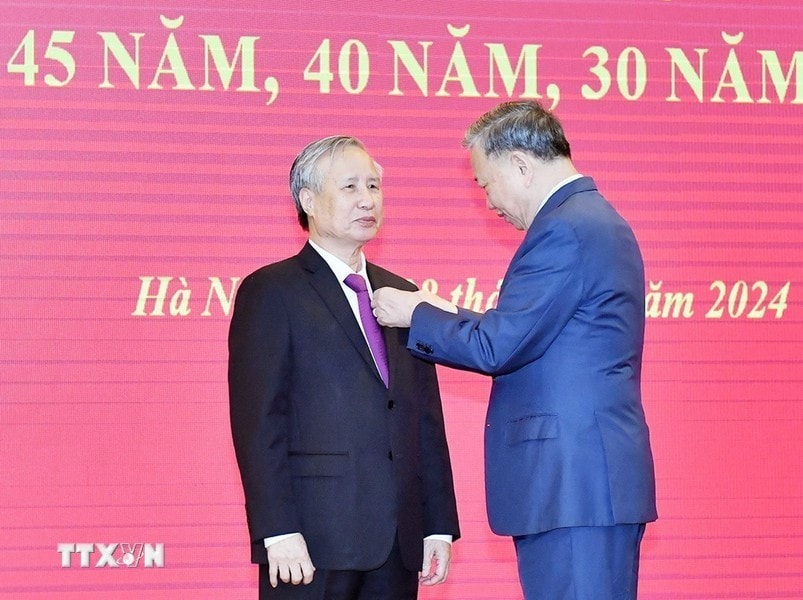 Tổng Bí thư Tô Lâm trao Huy hiệu 45 năm tuổi đảng tặng đồng chí Trần Quốc Vượng. Ảnh: Thống Nhất/TTXVN