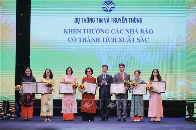 "Bộ trưởng Bộ Thông tin và Truyền thông Nguyễn Mạnh Hùng trao tặng Bằng khen của Bộ trưởng cho các Nhà báo xuất sắc. Ảnh: Minh Quyết - TTXVN"