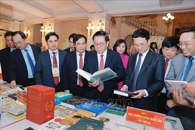 Trưởng Ban Tuyên giáo Trung ương Nguyễn Trọng Nghĩa; Bộ trưởng Thông tin và Truyền thông, Phó Trưởng Ban Tuyên giáo Trung ương Nguyễn Mạnh Hùng cùng các đại biểu tham quan khu trưng bày sách đoạt giải. Ảnh: Minh Quyết/TTXVN