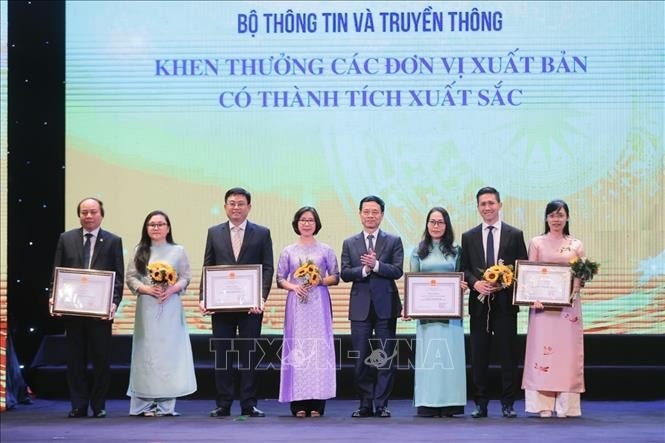Bộ trưởng Bộ Thông tin và Truyền thông Nguyễn Mạnh Hùng trao tặng Bằng khen của Bộ trưởng cho các đơn vị xuất bản có thành tích xuất sắc. Ảnh: Minh Quyết/TTXVN
