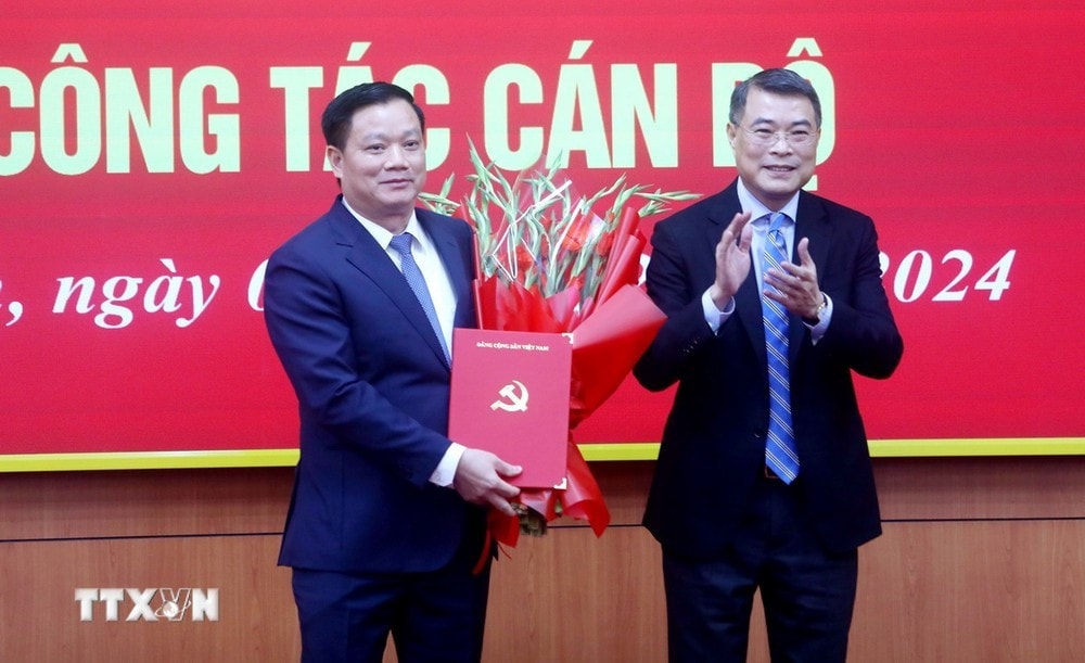Trưởng Ban Tổ chức Trung ương Lê Minh Hưng trao Quyết định, tặng hoa chúc mừng ông Nguyễn Khắc Thận. Ảnh: Thế Duyệt/TTXVN