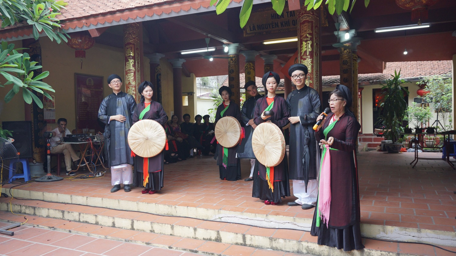 Liền chị Nguyễn Thị Chính (ngoài cùng bên phải), Câu lạc bộ quan họ Nhị Hà chia sẻ cho lớp trẻ về ý nghĩa trang phục của người hát quan họ. Ảnh: Thái Minh