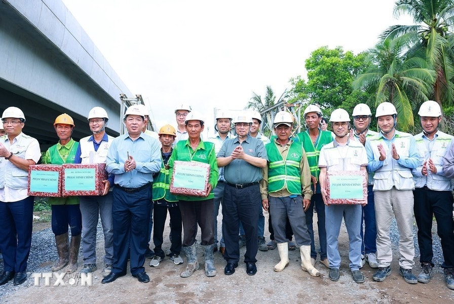 Thủ tướng Phạm Minh Chính tặng quà công nhân thi công cao tốc đoạn Cần Thơ-Hậu Giang. Ảnh: Dương Giang/TTXVN