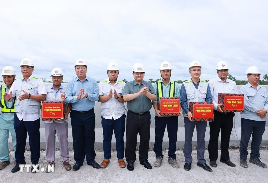 Thủ tướng Phạm Minh Chính tặng quà công nhân thi công cao tốc Cần Thơ-Cà Mau đoạn qua huyện Phụng Hiệp, tỉnh Hậu Giang. Ảnh: Dương Giang/TTXVN
