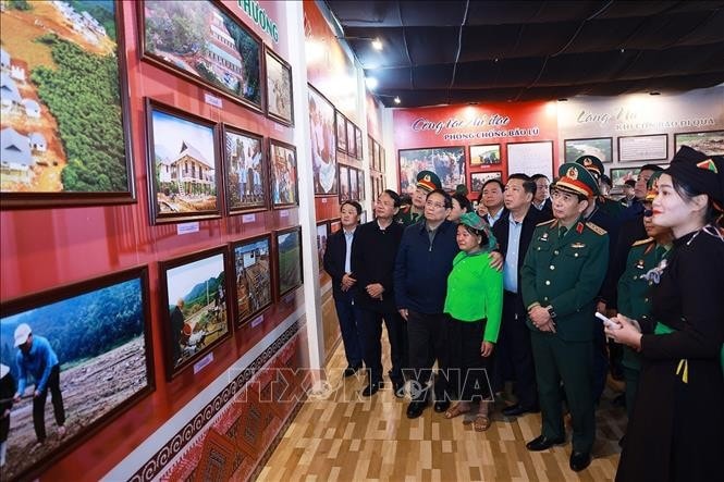 Thủ tướng Phạm Minh Chính tham quan trưng bày ảnh, hiện vật và gặp người dân có người thân thiệt mạng trong trận lũ quét tại Nhà văn hóa thôn Làng Nủ. Ảnh: Dương Giang/TTXVN
