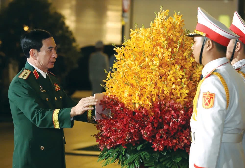 Bộ trưởng Bộ Quốc phòng, Đại tướng Phan Văn Giang chỉnh lẵng hoa tưởng niệm trước Tượng đài Chủ tịch Hồ Chí Minh. Ảnh: Thái Phương