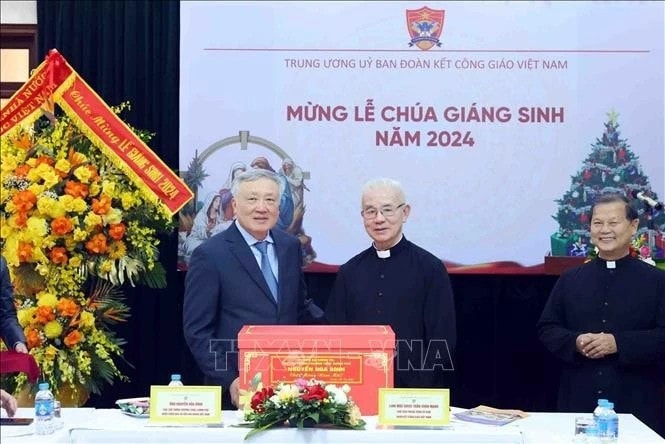 Standing Deputy Prime Minister Nguyen Hoa Binh (left) presents a X-mas gift to the Central Committee for Solidarity of Vietnamese Catholics on December 22. (Photo: VNA) vna-nguyen-hoa-binh-xmas-greetings.jpg