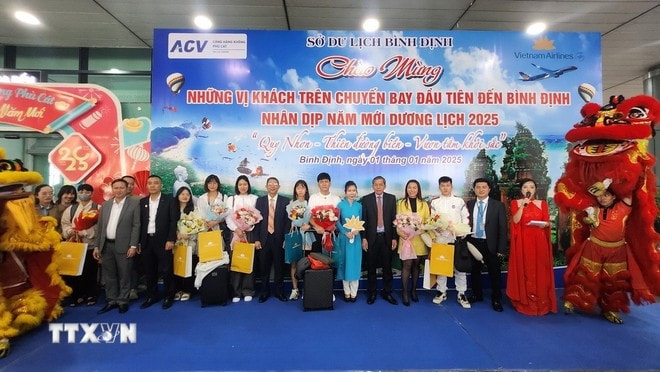 Tặng hoa và quà cho các vị khách xông đất đầu năm 2025. Ảnh: Sỹ Thắng/TTXVN