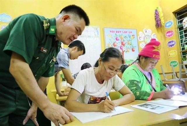 Lieutenant Lo Thanh Chuyen of the Leng Su Sin Border Guard Station assists teachers in a class in Ca Na Pa village in Diện Bien province. (Photo: VNA) long.jpg