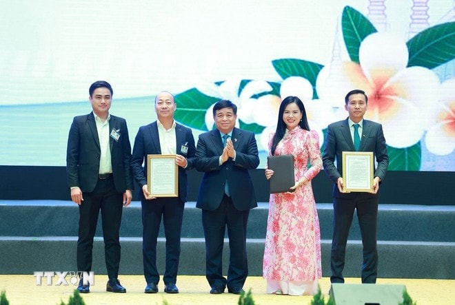 Bộ trưởng Bộ Kế hoạch và Đầu tư Nguyễn Chí Dũng trao chứng nhận đăng ký và thỏa thuận đầu tư cho các doanh nghiệp Việt Nam có hợp tác với Lào. Ảnh: Dương Giang/TTXVN