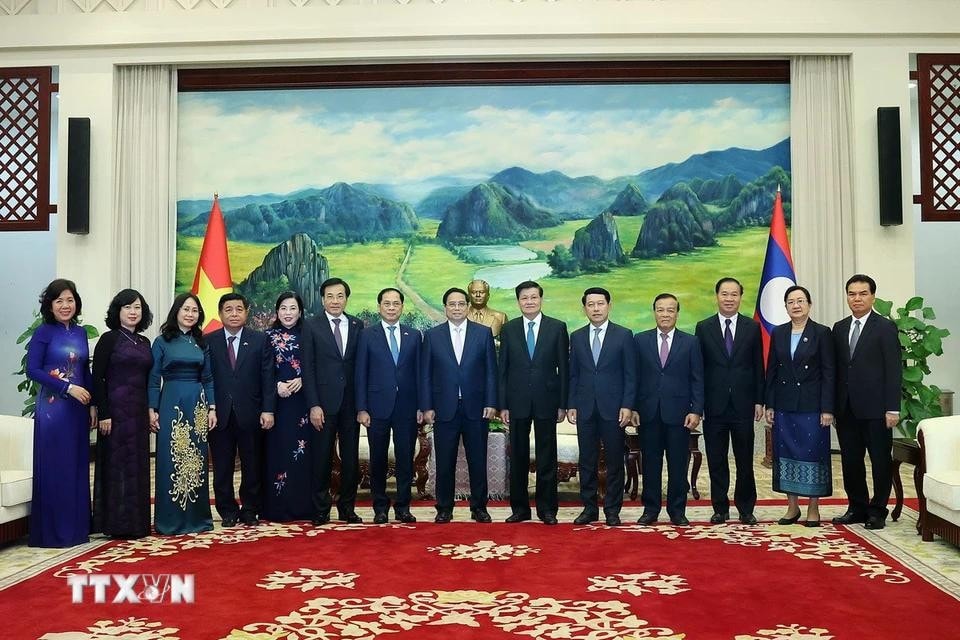 Thủ tướng Phạm Minh Chính và Tổng Bí thư, Chủ tịch nước Lào Thongloun Sisoulith với thành viên đoàn hai nước. Ảnh: Dương Giang/TTXVN
