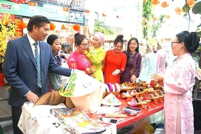 Vietnamese Ambassador to Malaysia Dinh Ngoc Linh (L) visits a booth at the event (Photo: VNA) tet.jpg
