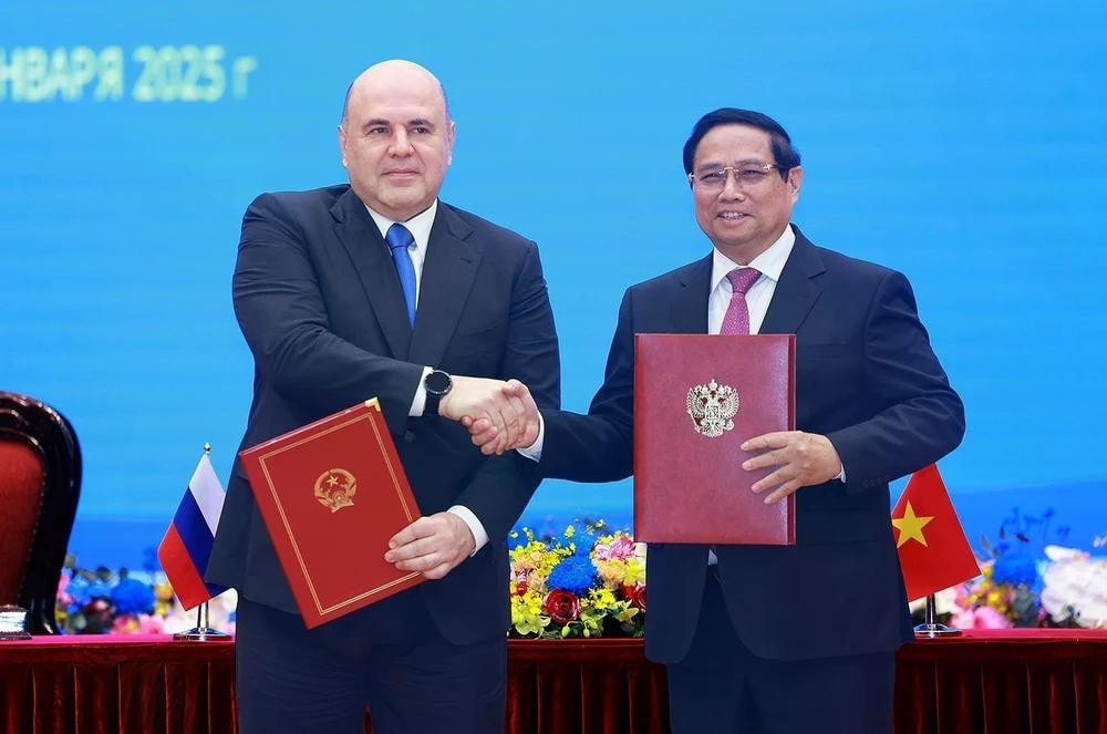 Prime Minister Pham Minh Chinh (R) and his Russian counterpart Mikhail Vladimirovich Mishustin sign a joint communiqué on the results of the Rusian PM's official visit to Vietnam. (Photo: VNA) img-6312.jpg