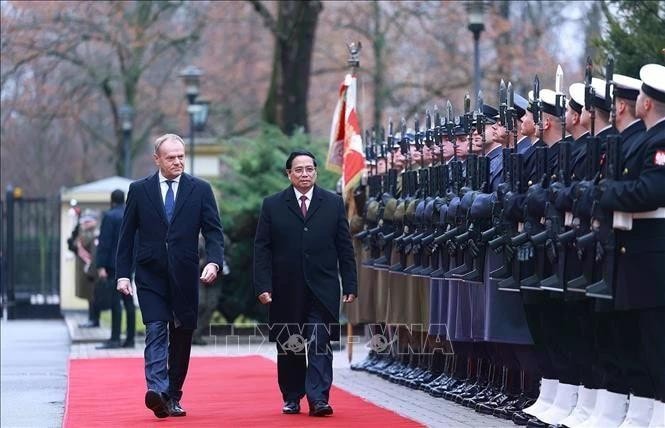 Prime Minister Pham Minh Chinh (R) and Polish Prime Minister Donald Tusk inspect the guard of honour at the welcome ceremony. (Photo: VNA) img-6378.jpg