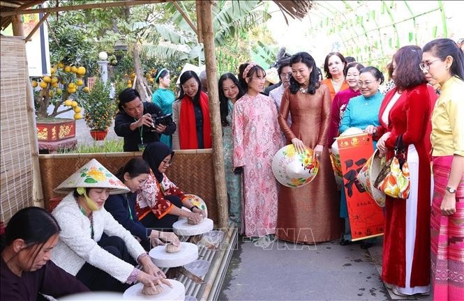 Bà Ngô Phương Ly, Phu nhân Tổng Bí thư Tô Lâm và các đại biểu xem các nghệ nhân làm gốm. Ảnh: Văn Điệp/TTXVN