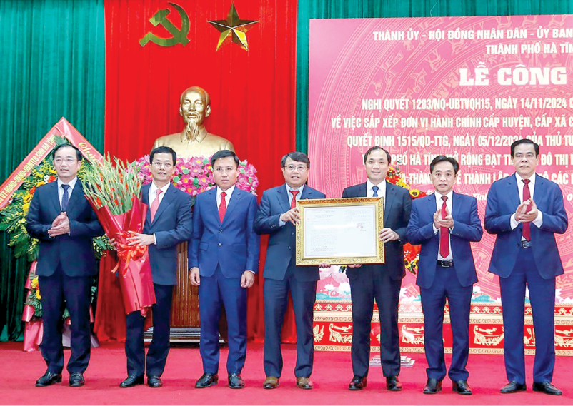 Các đồng chí Thường trực Tỉnh ủy trao nghị quyết của Ủy ban Thường vụ Quốc hội về sắp xếp đơn vị hành chính và tặng hoa chúc mừng Thường trực Thành ủy thành phố Hà Tĩnh