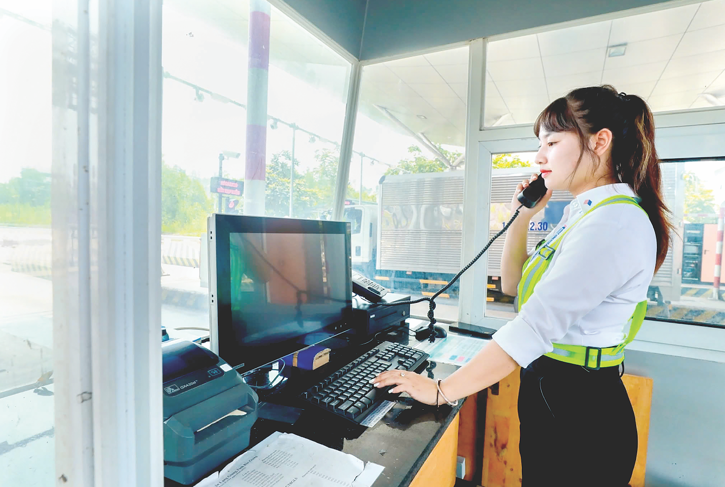 Nữ nhân viên trạm thu phí cao tốc Bắc Giang – Lạng Sơn có nhiệm vụ báo cáo tình hình lưu lượng phương tiện đi qua, phối hợp với lực lượng chức năng để xử lý các tình huống khẩn cấp