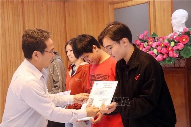 Pham Minh Tuan, Vice Chairman of Ho Chi Minh City’s Vietnam Fatherland Front Committee, presents health insurance cards to impoverished students. (Photo: VNA) tang-160125.jpg