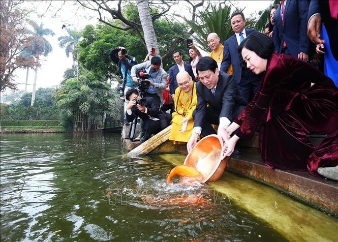 Chủ tịch nước Lương Cường và Phu nhân thả cá chép tiễn ông Công, ông Táo tại Ao cá Bác Hồ trong Khu di tích Phủ Chủ tịch. Ảnh: Lâm Khánh/TTXVN