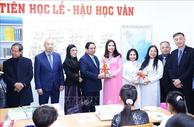 Thủ tướng Phạm Minh Chính và Phu nhân tặng sách cho lớp học Tiếng Việt tại Trung tâm Thương mại Sapa tại thủ đô Praha. Ảnh: Dương Giang/TTXVN