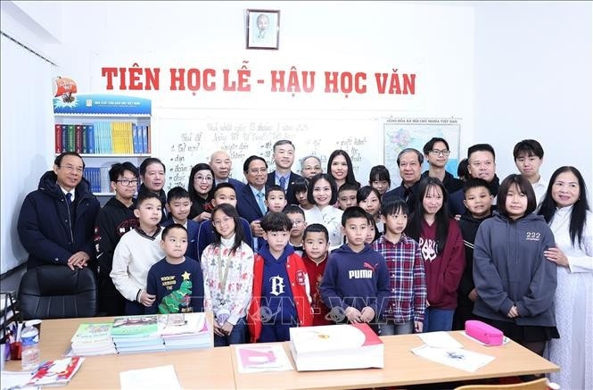 Thủ tướng Phạm Minh Chính và Phu nhân với giáo viên và học sinh lớp Tiếng Việt cho trẻ em tại Trung tâm Thương mại Sapa tại thủ đô Praha. Ảnh: Dương Giang/TTXVN