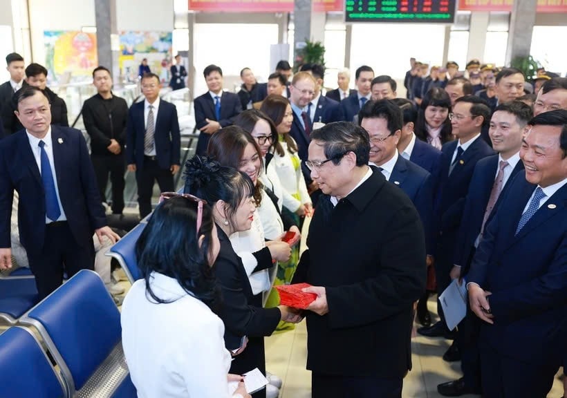 Prime Minister Pham Minh Chinh presents lucky money to passengers at the Hanoi Railway Station. (Photo: VNA) z6269366020412-511b7c82ea59ba53b668145535d962d6.jpg