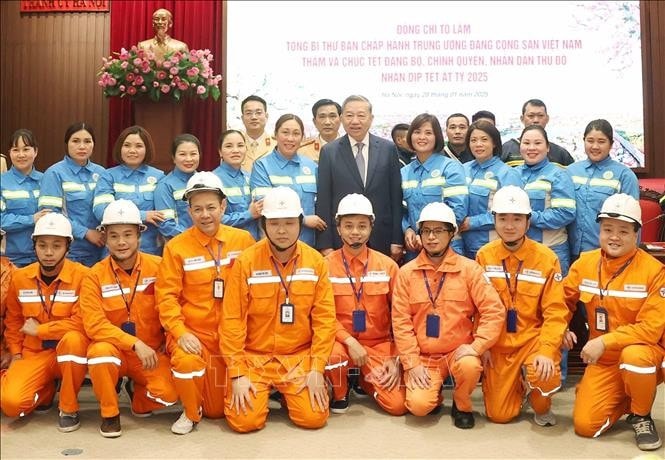 Tổng Bí thư Tô Lâm chụp ảnh chung với cán bộ, công nhân ngành điện lực và môi trường đô thị ứng trực, làm việc trong đêm Giao thừa. Ảnh: Thống Nhất/TTXVN