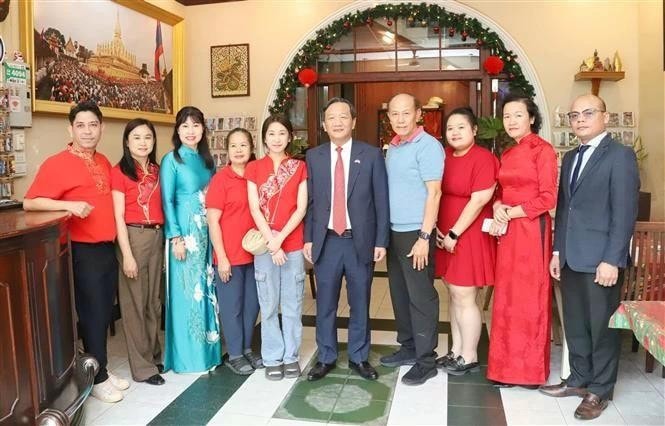 From right: Ambassador Nguyen Minh Tam (5th) and the family of Le Dung (4th), former president of the Vietnamese Association in Vientiane. (Photo: VNA) img-3850.jpg