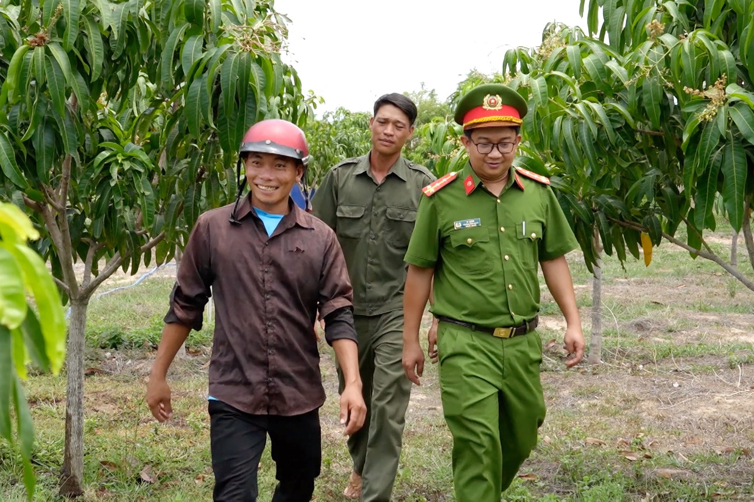 Đại úy K’Sáng cùng người dân xã Phan Lâm bên mô hình kinh tế mới, góp phần cải thiện thu nhập. Ảnh: Thạc Hiếu