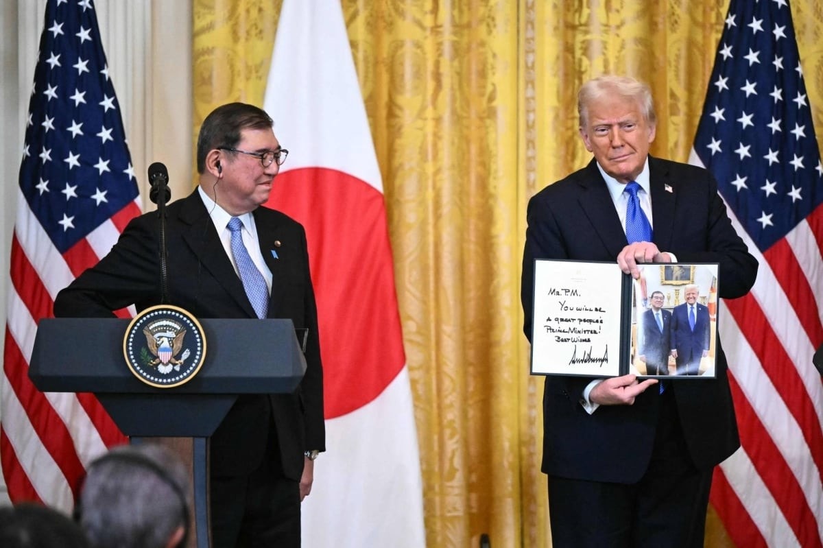 Tổng thống Mỹ Donald Trump giới thiệu tấm ảnh chụp chung với Thủ tướng Shigeru Ishiba tại cuộc họp báo chung ngày 7.2. Ảnh: Japan Times