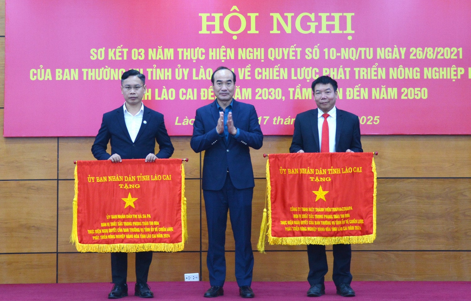 Phó Bí thư Thường trực Tỉnh ủy Lào Cai Vũ Xuân Cường tặng Cờ thi đua của UBND tỉnh cho 2 tập thể có thành tích xuất sắc trong thực hiện Nghị quyết số 10-NQ/TU của Ban Thường vụ Tỉnh ủy. Ảnh: laocai.gov.vn
